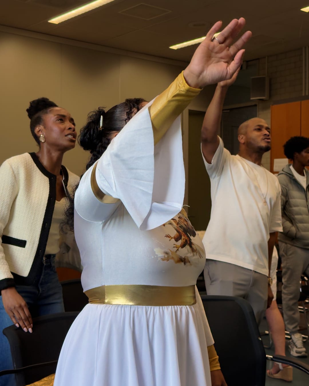 The FaithReign congregation worshipping with hands raised during a service